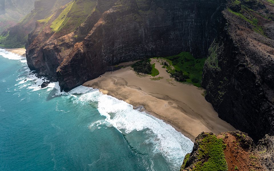 A beach with waves coming in from the ocean.