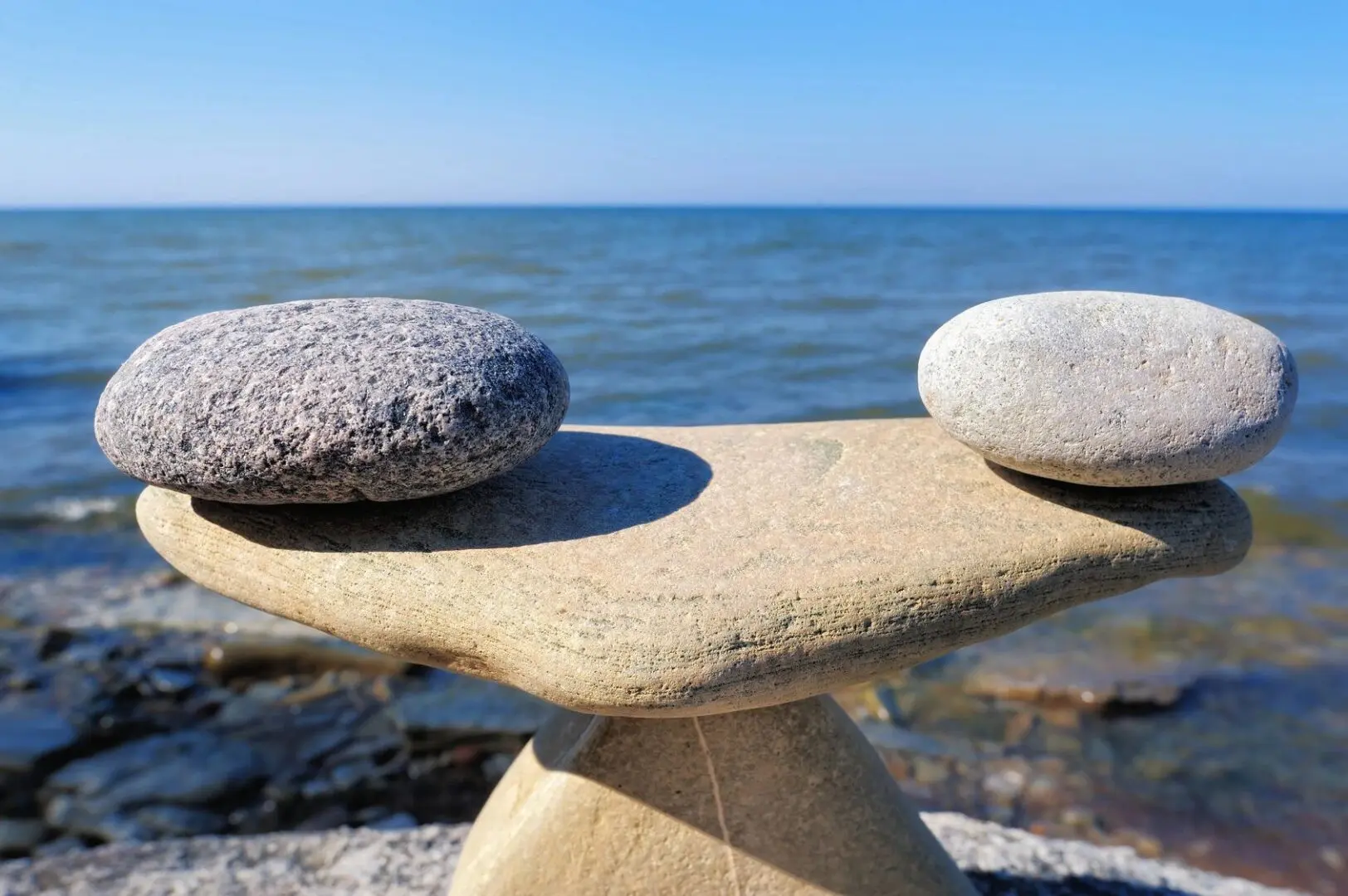 Two rocks on a table near the ocean